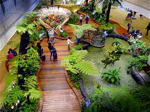 A Singapore airport with a large green area and a pond