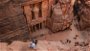 Person looking down at Petra The Treasury during the day on rock