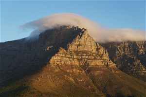 Table mountain at dusk with clouds rolling over the top