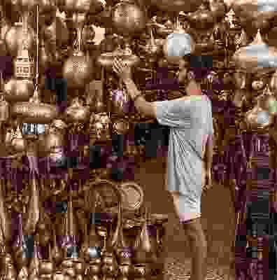 Man traveller looking at the traditional metal lamps in Marrakesh.