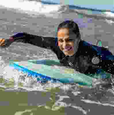 Women surfing the waves at Taghazout beach.