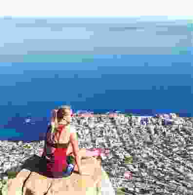 Women sat on a rock over looking Cape Town after hike.